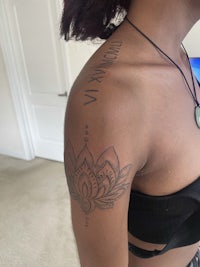 a woman with a lotus tattoo on her shoulder